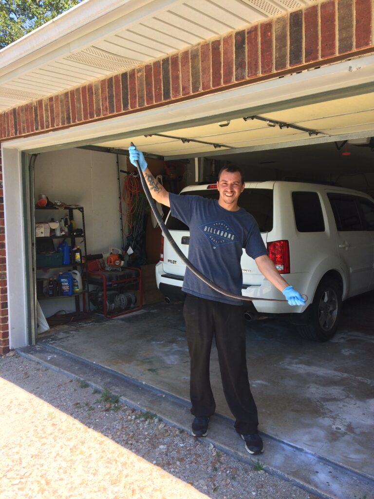 my son holding a 6 foot black snake caught in a garage